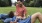 a man and a woman sitting on grass